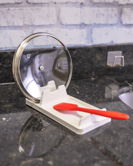 Weißer Topfdeckelhalter 2-in-1 mit rotem Pfannenwender und Glasdeckel auf Arbeitsplatte